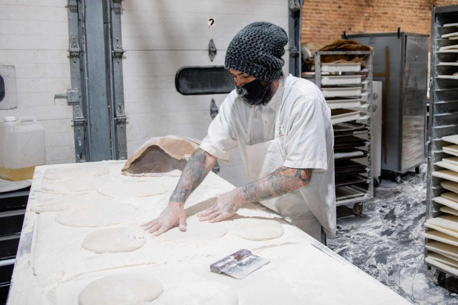 A person pressing against mounds of dough.