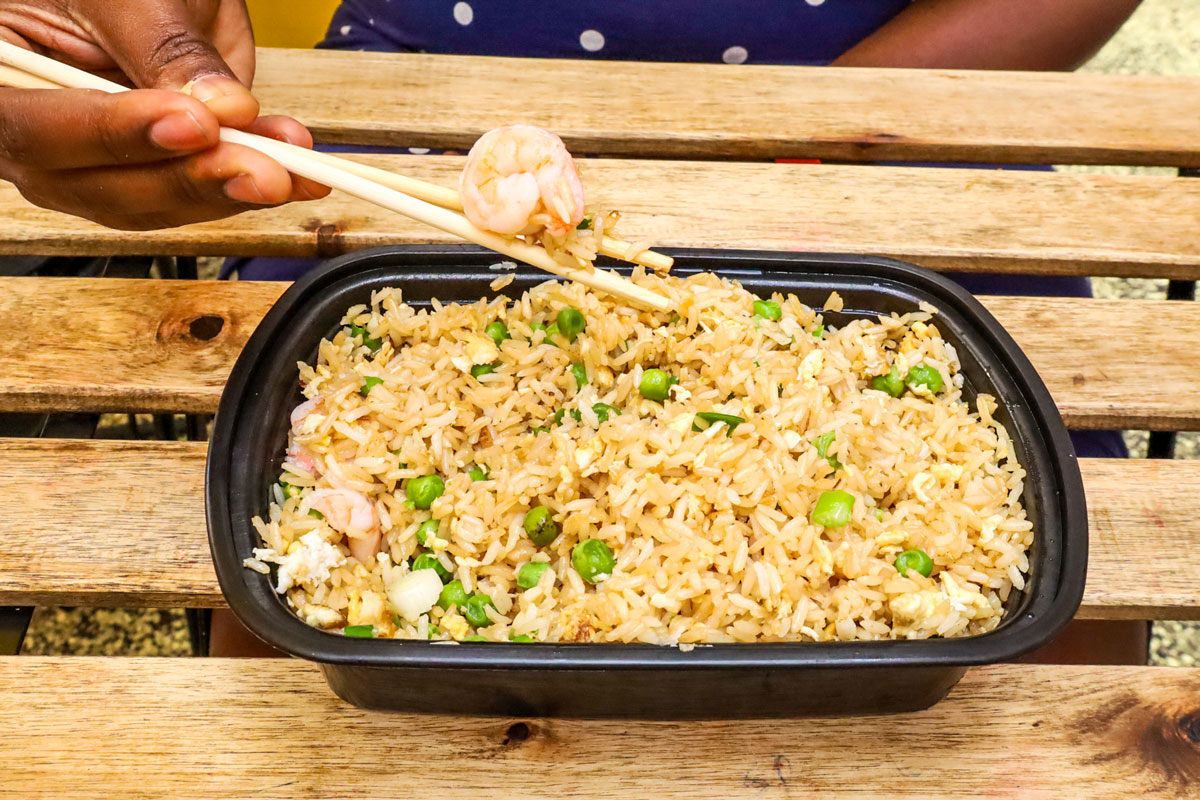 A black container filled with fried rice.