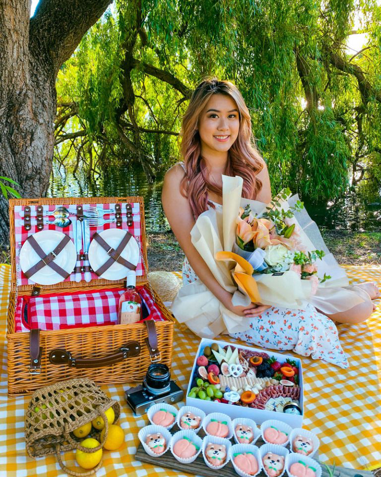 A person posing for a photo sitting at a picnic.