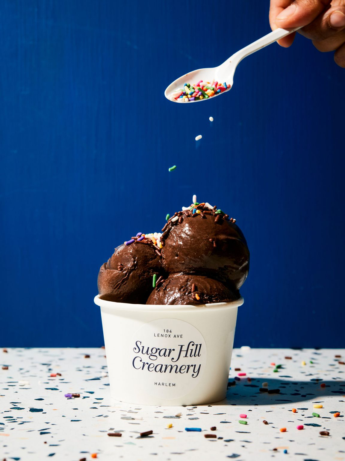 Sprinkles being sprinkled on top of ice cream.