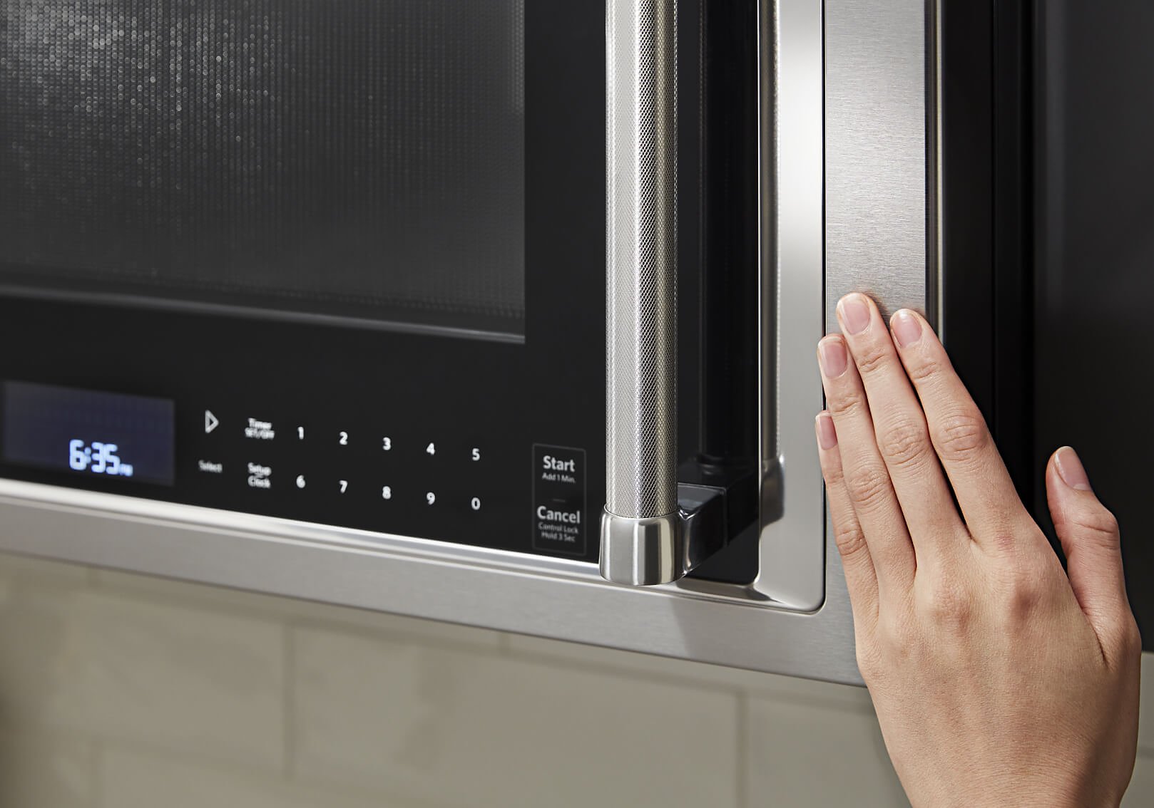 Hand closing a stainless steel microwave Hand closing a stainless steel microwave
