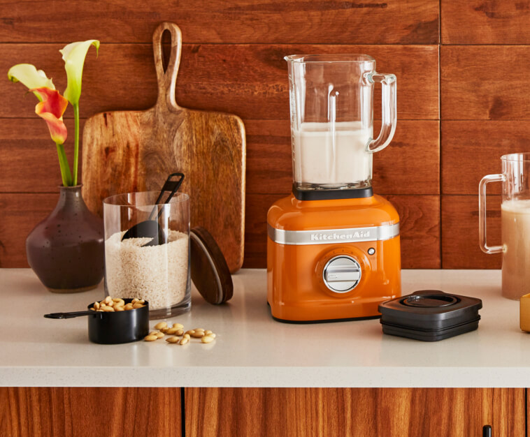 KitchenAid® Blender in Honey against a wooden backsplash