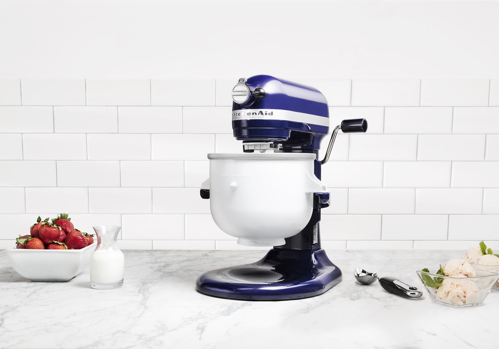 A KitchenAid® bowl-lift stand mixer with strawberries and milk.