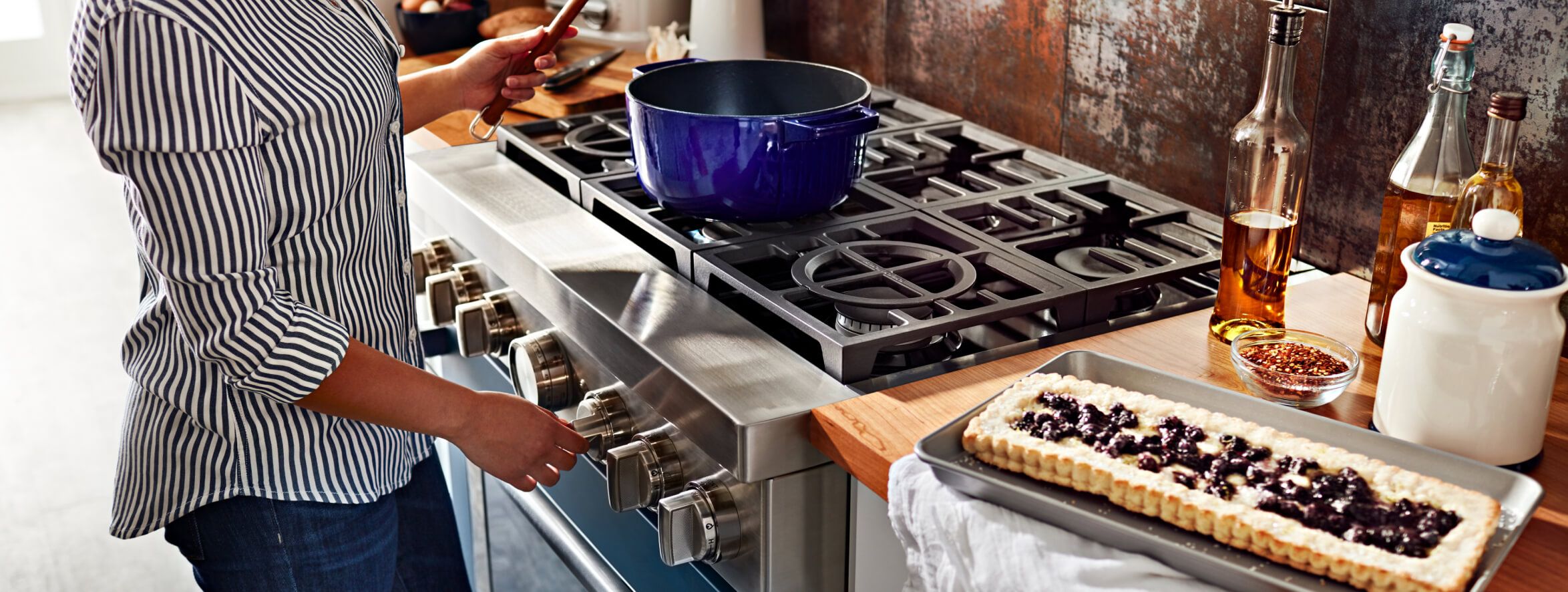 Woman cooking on a blue commercial-style range