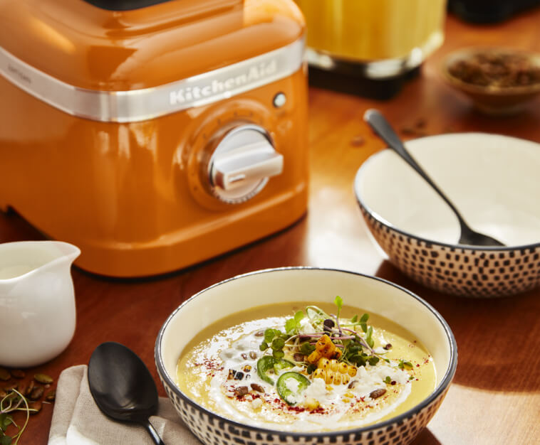 KitchenAid® blender in Honey next to a bowl of soup 