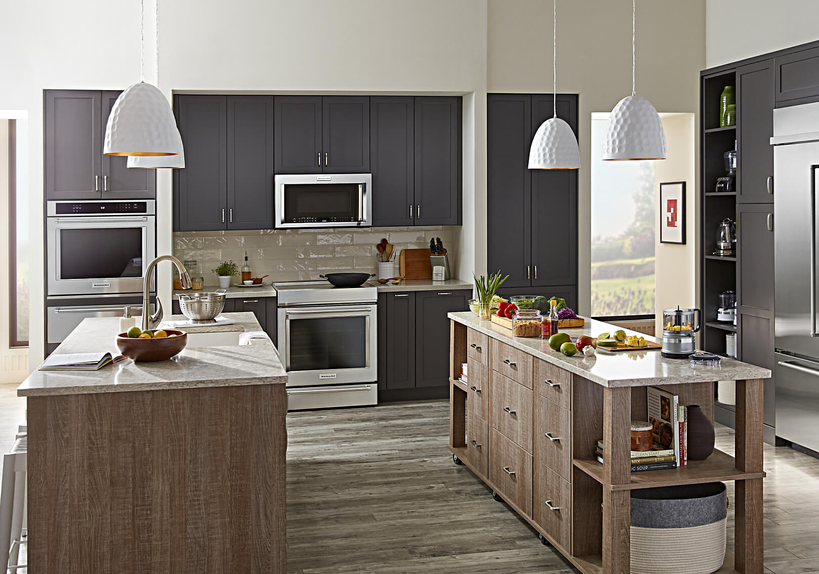 Modern kitchen with grey cabinets, wood paneled island and stainless KitchenAid® appliances.