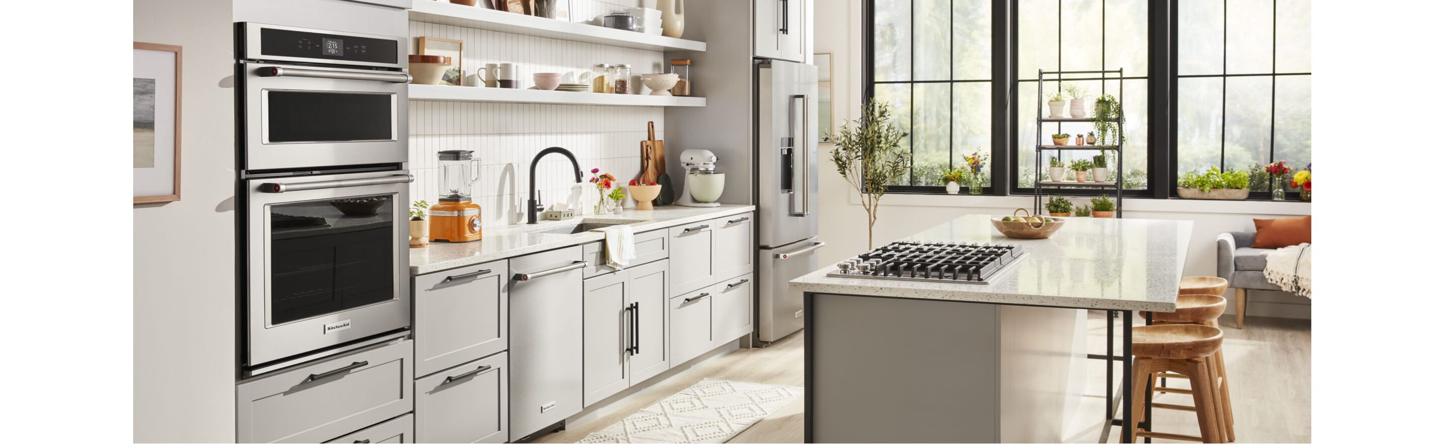 White kitchen with large island and  KitchenAid® appliances.