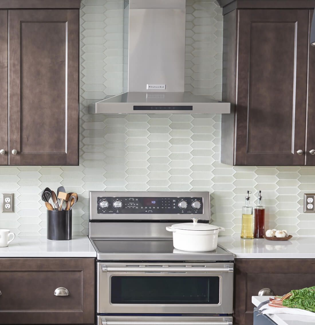 Wall-mount canopy hood between brown cabinets