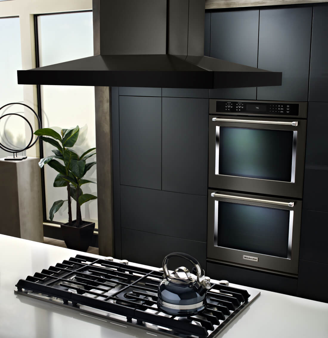 Black island canopy hood over a gas cooktop