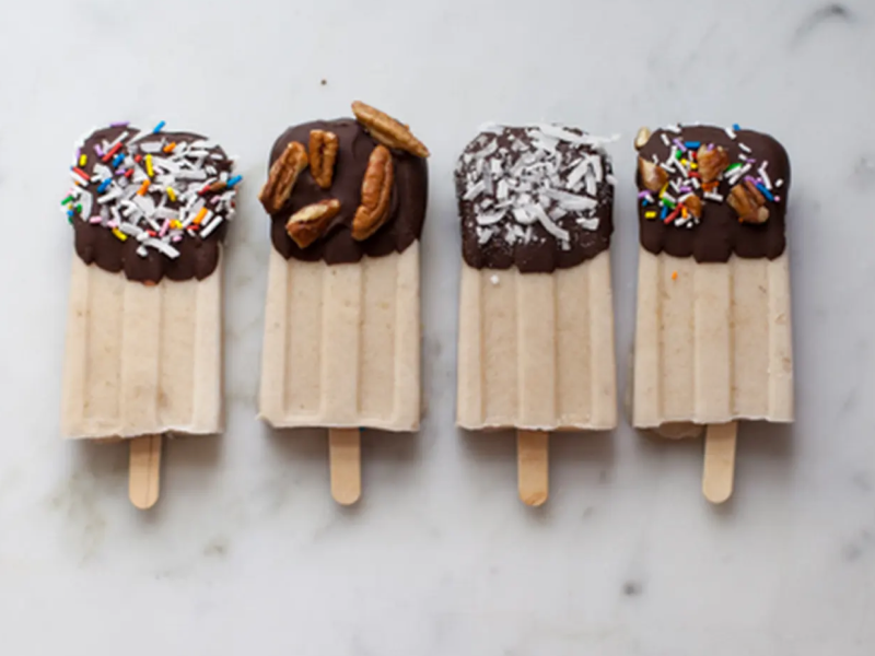 Chocolate dipped banana popsicles on a countertop