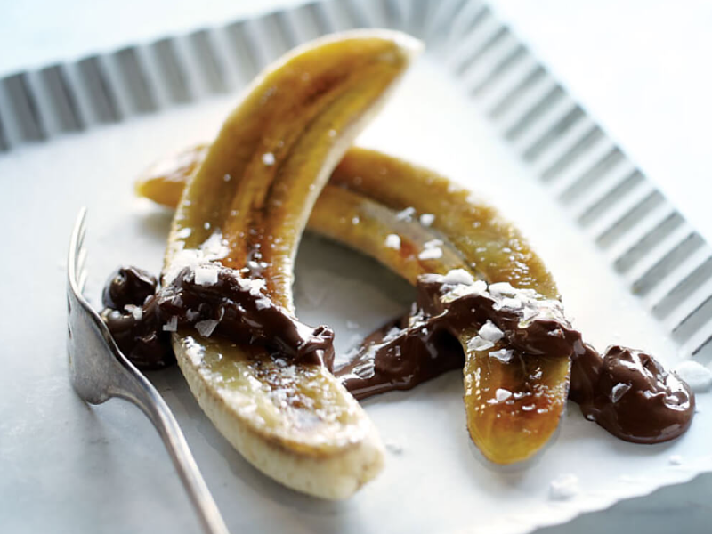 Caramelized bananas on a plate with chocolate drizzle