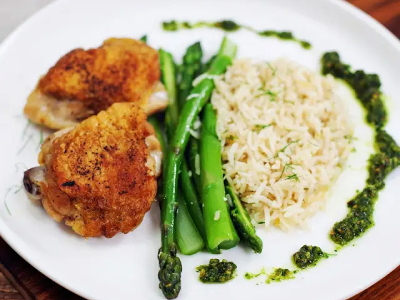 Close-up of dinner plate with roasted chicken with rice pilaf and asparagus