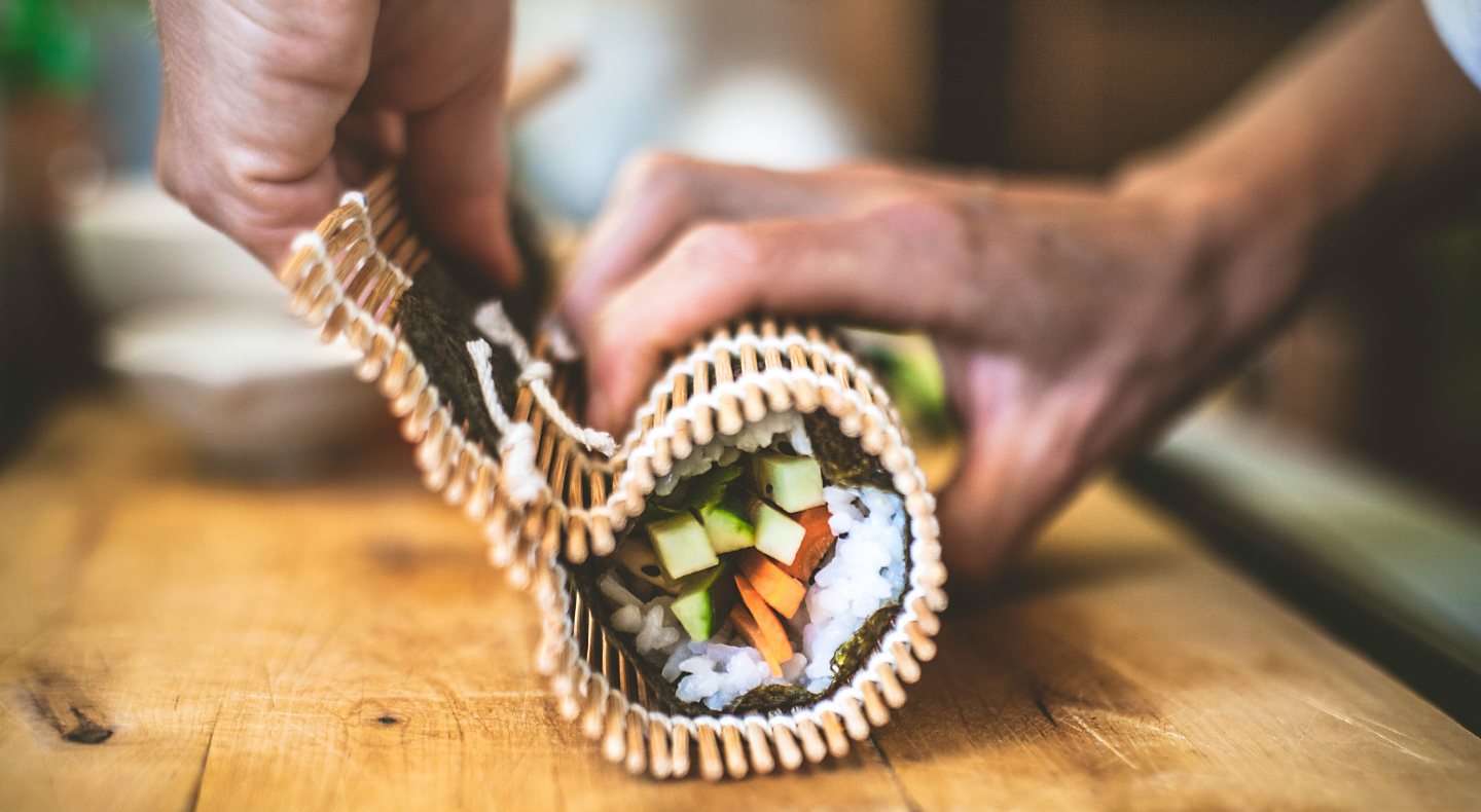 Close-up of person rolling sushi