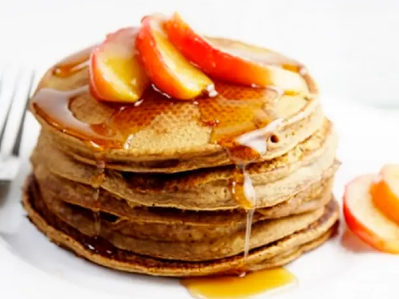 Stack of gingerbread pancakes topped with fresh fruit and syrup