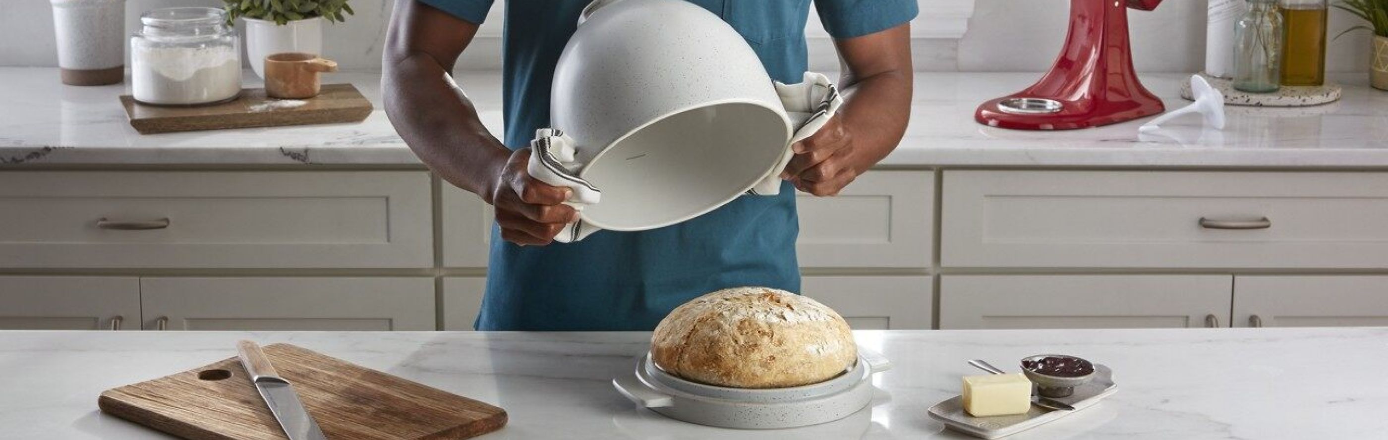 Person removing bread from a KitchenAid® Bread Bowl with Lid