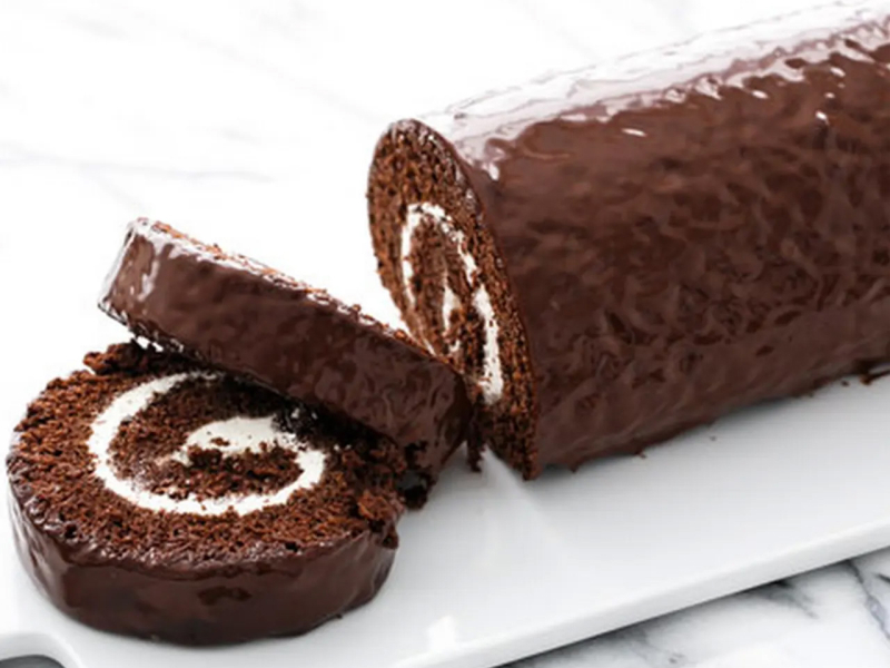 Chocolate swiss roll on white serving platter