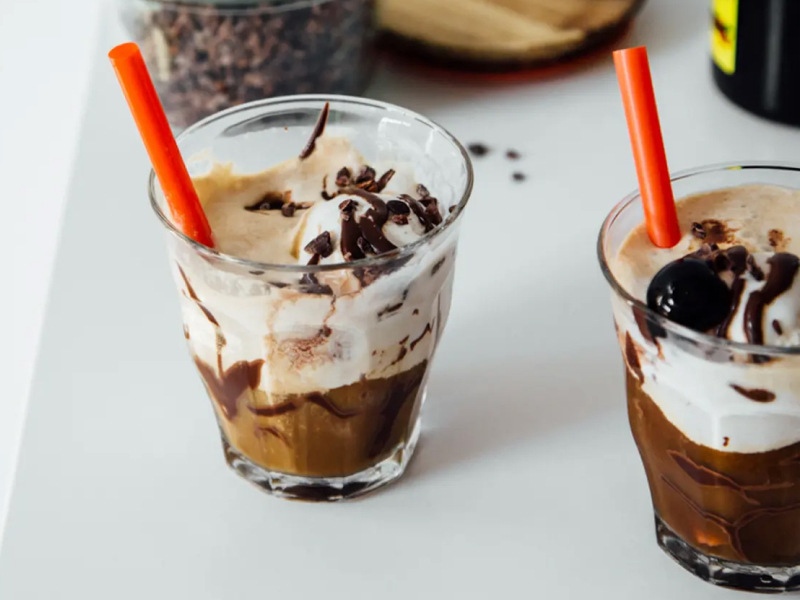 Cold brew floats with orange straws in clear glasses