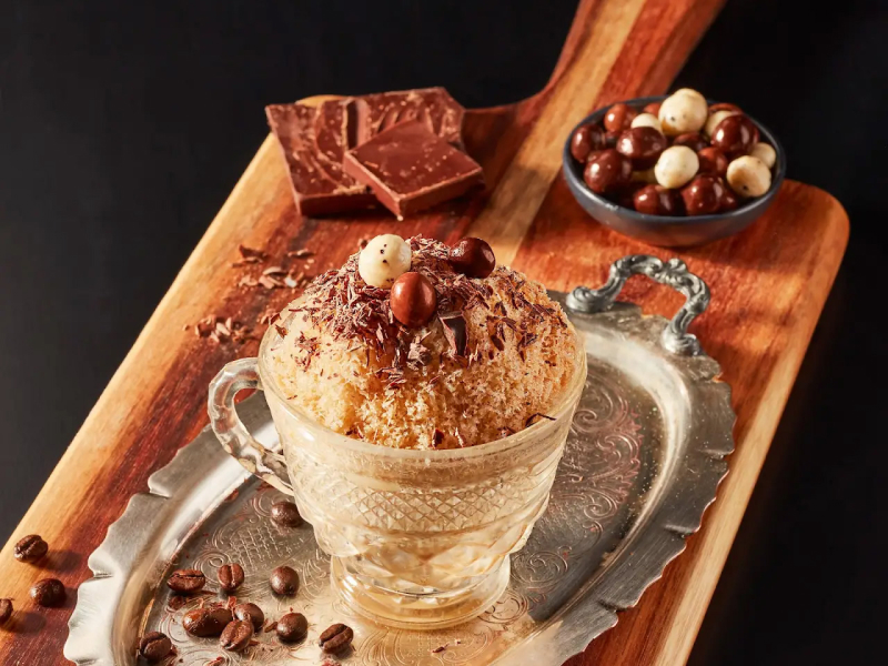 Shave ice in a glass dish with espresso beans and dessert garnishes