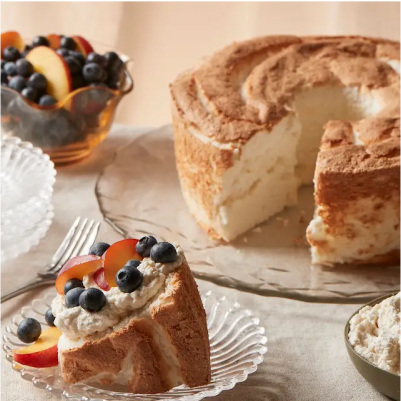 An angel food cake with whipped cream and berries.