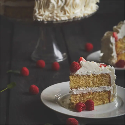 A slice of vanilla butter cake with raspberries.