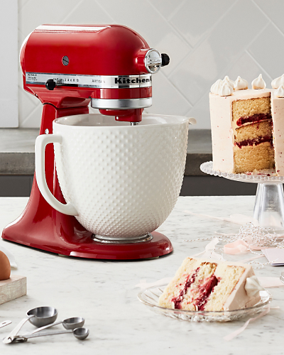 A red KitchenAid® stand mixer with cake ingredients nearby.