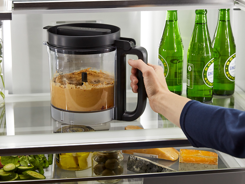 Person removing food processor bowl from refrigerator