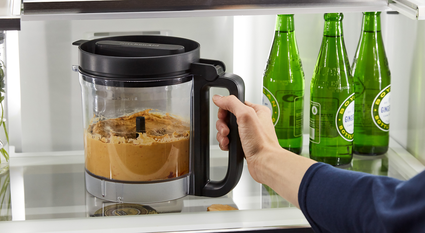 Person removing food processor bowl from refrigerator