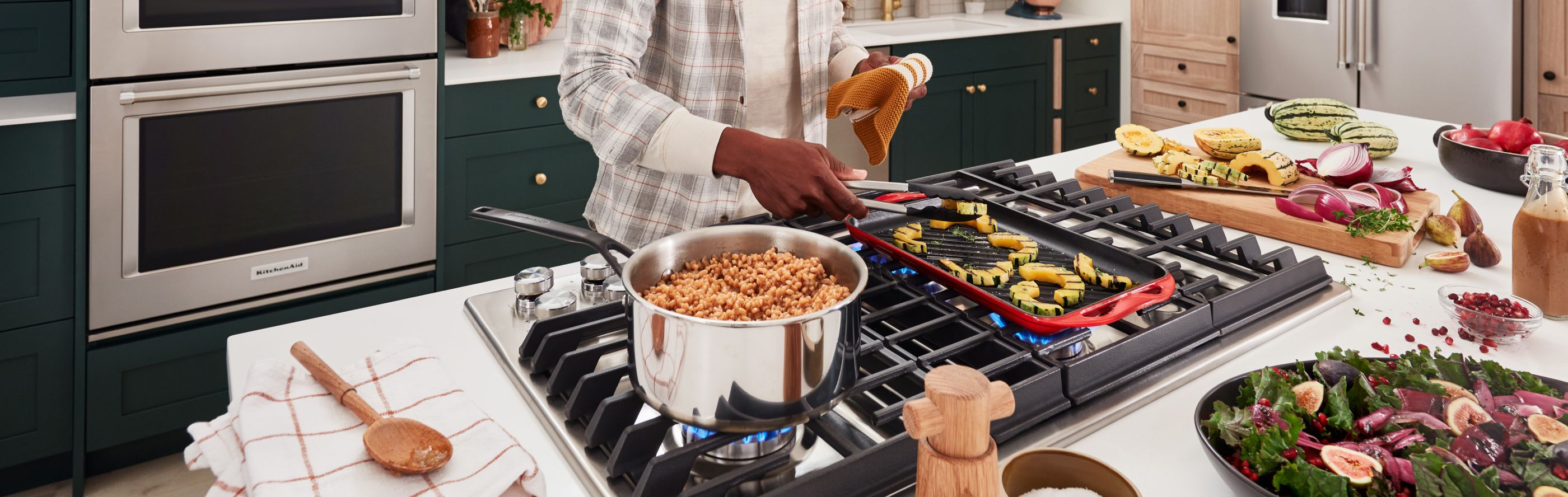 Person preparing food at a cooktop built into a kitchen island