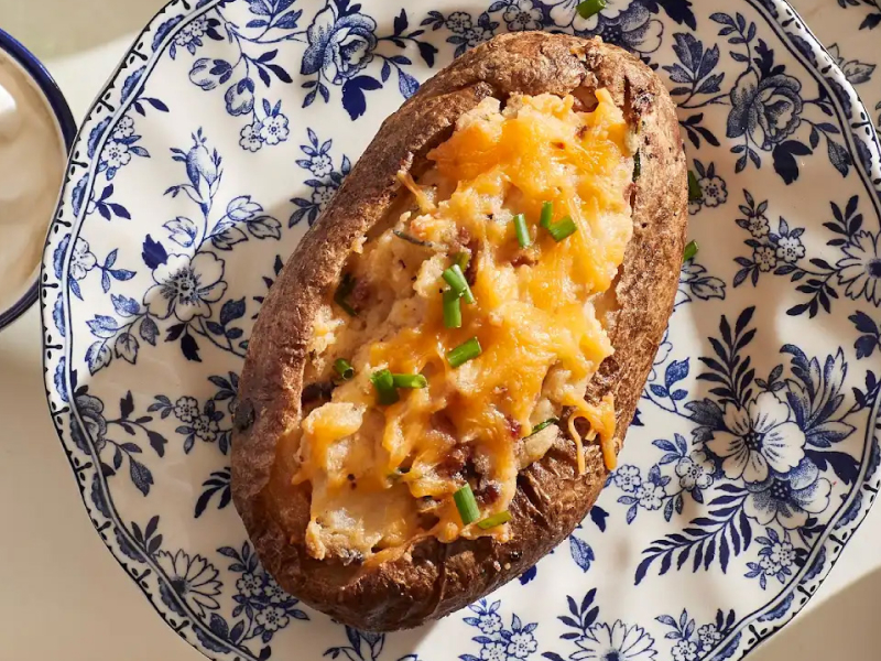 Twice baked potato on blue and white plate 