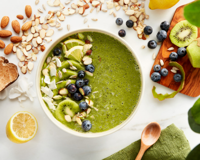 Green smoothie bowl topped with blueberries, kiwi and shaved almonds
