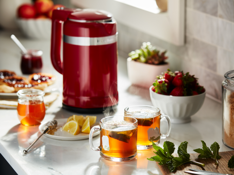 Red KitchenAid® electric kettle next to tea ingredients