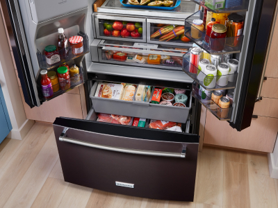 Stocked KitchenAid® refrigerator with doors and freezer drawer open