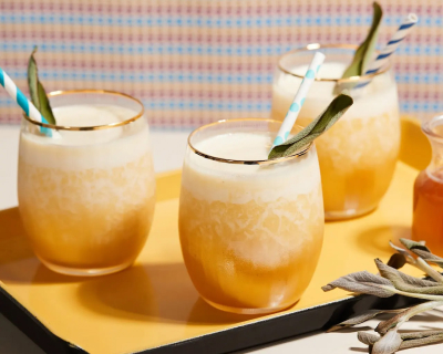 Sage honey pineapple blended cocktails in glasses on tray