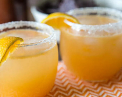 Citrus margaritas in glasses with salt and lemon wedges on the rims