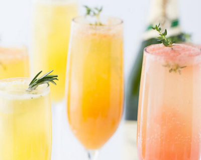 Various flavors of mimosas with green leaf garnishes