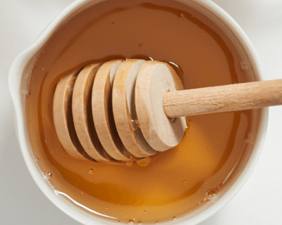 Honey in a bowl with a honey dipper