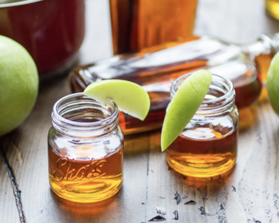 Two small mason jars of caramel apple infused bourbon