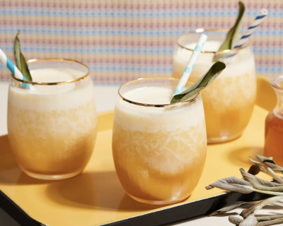 Three glasses of sage honey pineapple blended cocktails on a tray