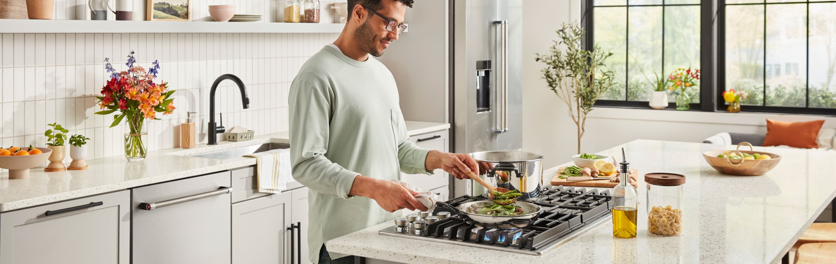Person cooking vegetables on a kitchen island cooktop