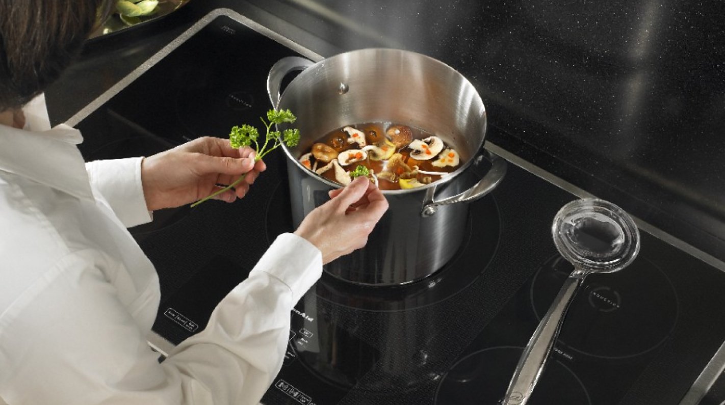 Person seasoning vegetable soup Person seasoning vegetable soup