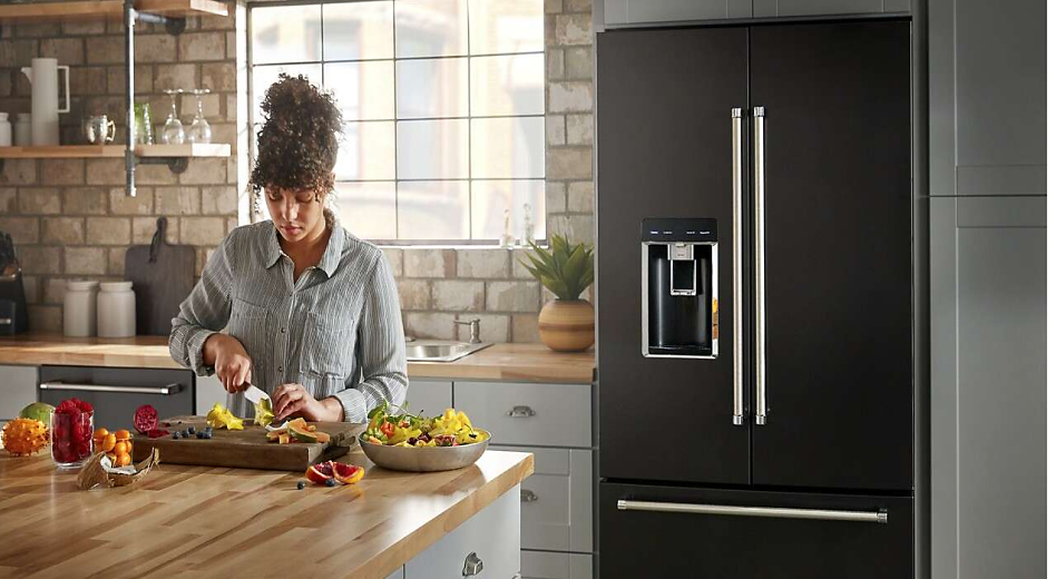 Person preparing food next to a French door refrigerator