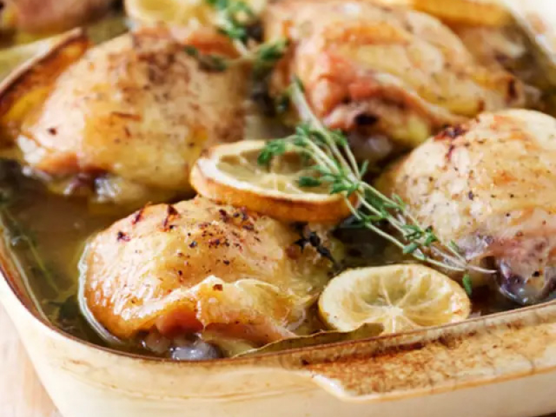 Broiled chicken with lemon peels on top.