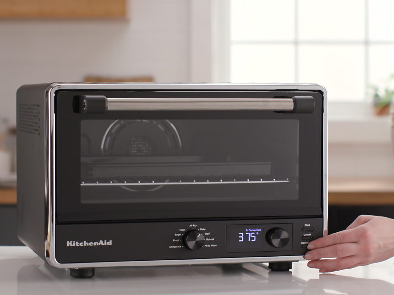Person choosing a setting on a countertop oven