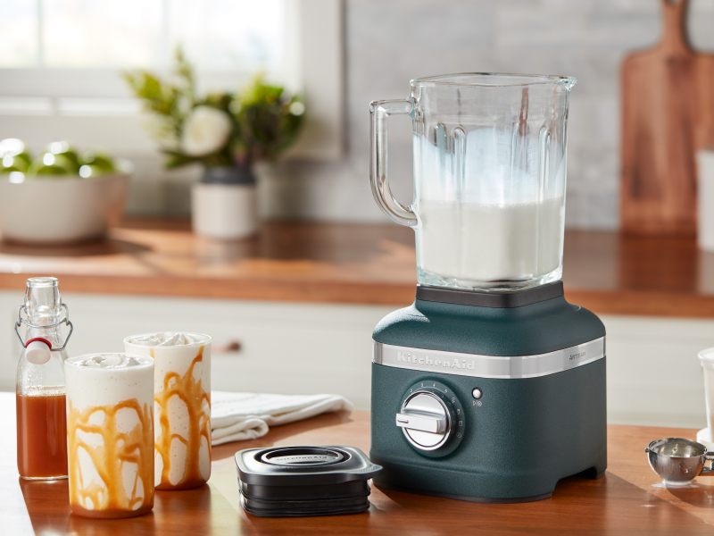 A KitchenAid® blender with milkshake ingredients on a modern kitchen counter.
