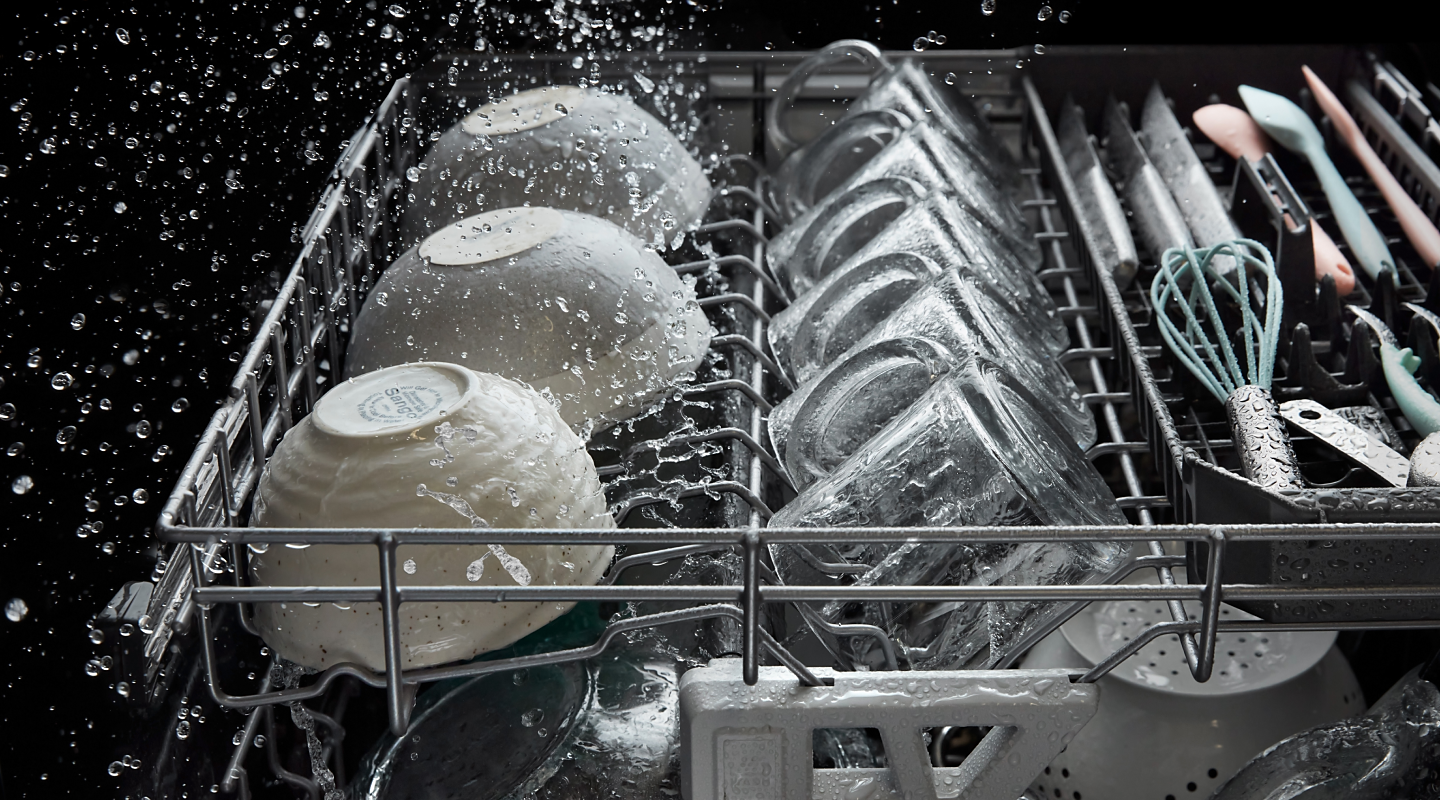 Dishes and glassware being washed inside a dishwasher
