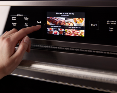 Person selecting settings on the digital display of an oven 