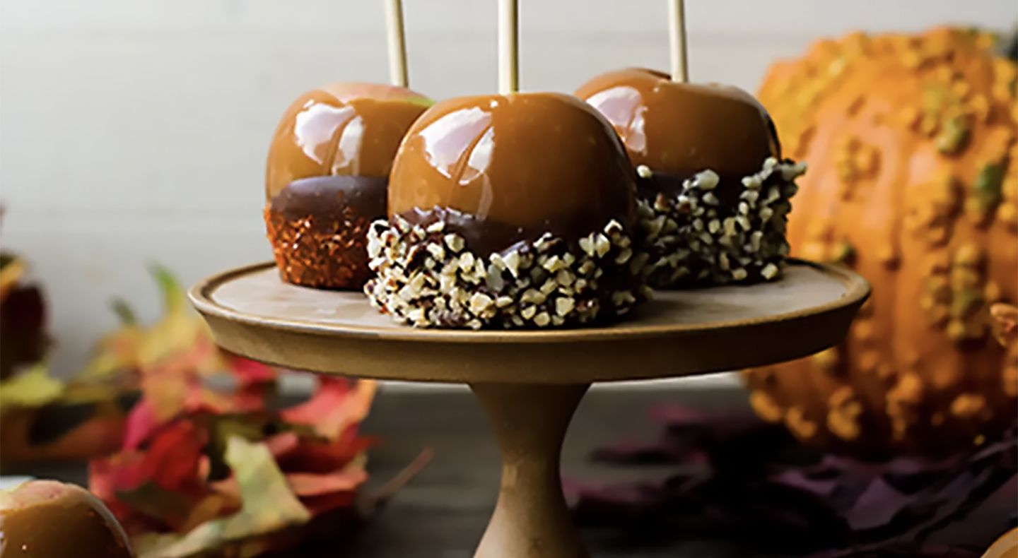 Caramel apples dipped in chocolate and chopped nuts