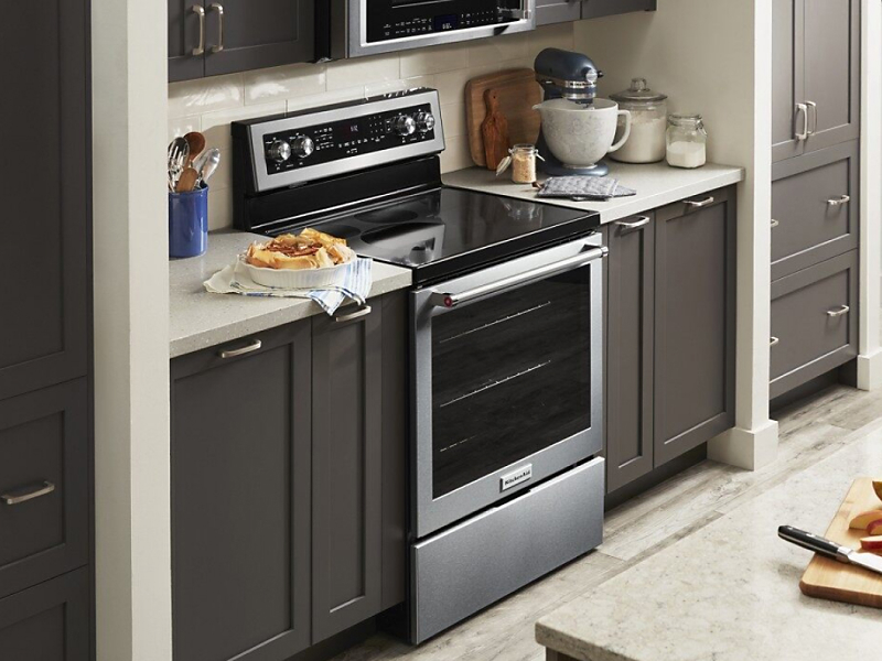 Stainless steel range in a kitchen with dark wood cabinets 