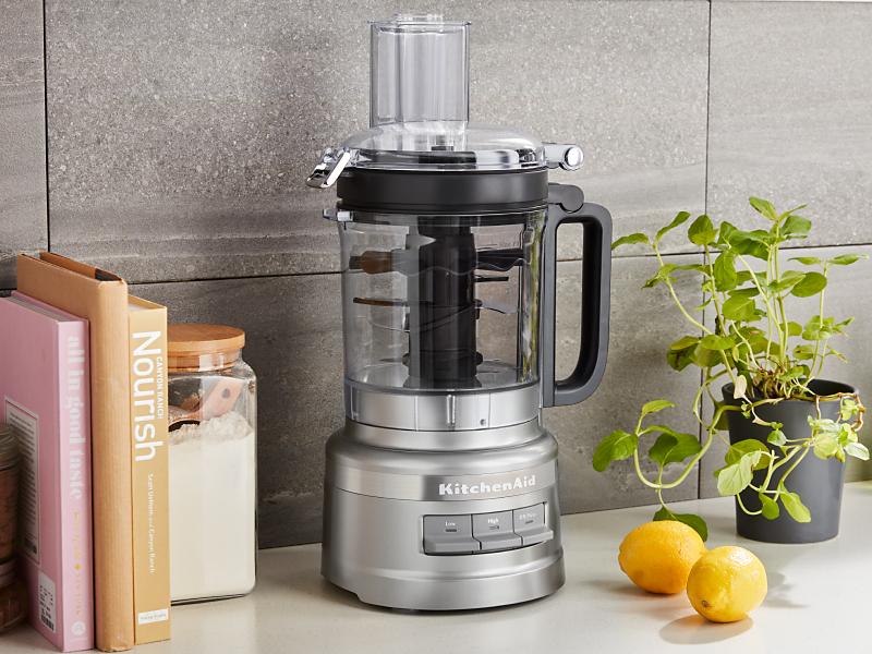 Large silver food processor on the counter with lemons