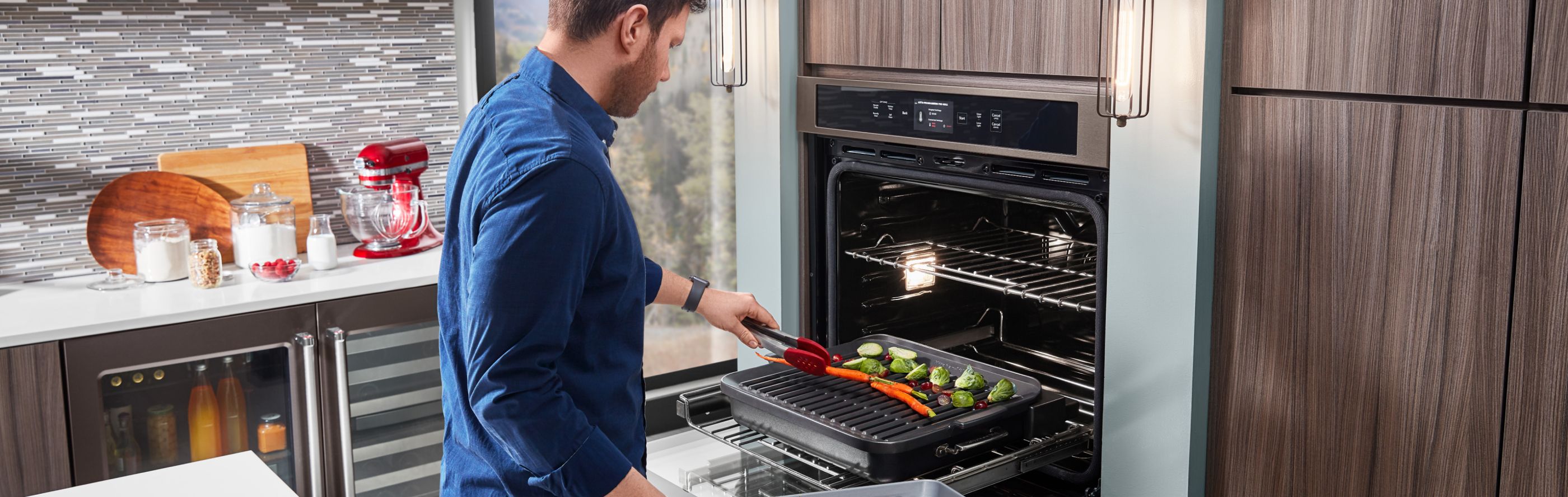 Person grilling vegetables in a KitchenAid® Smart Oven+